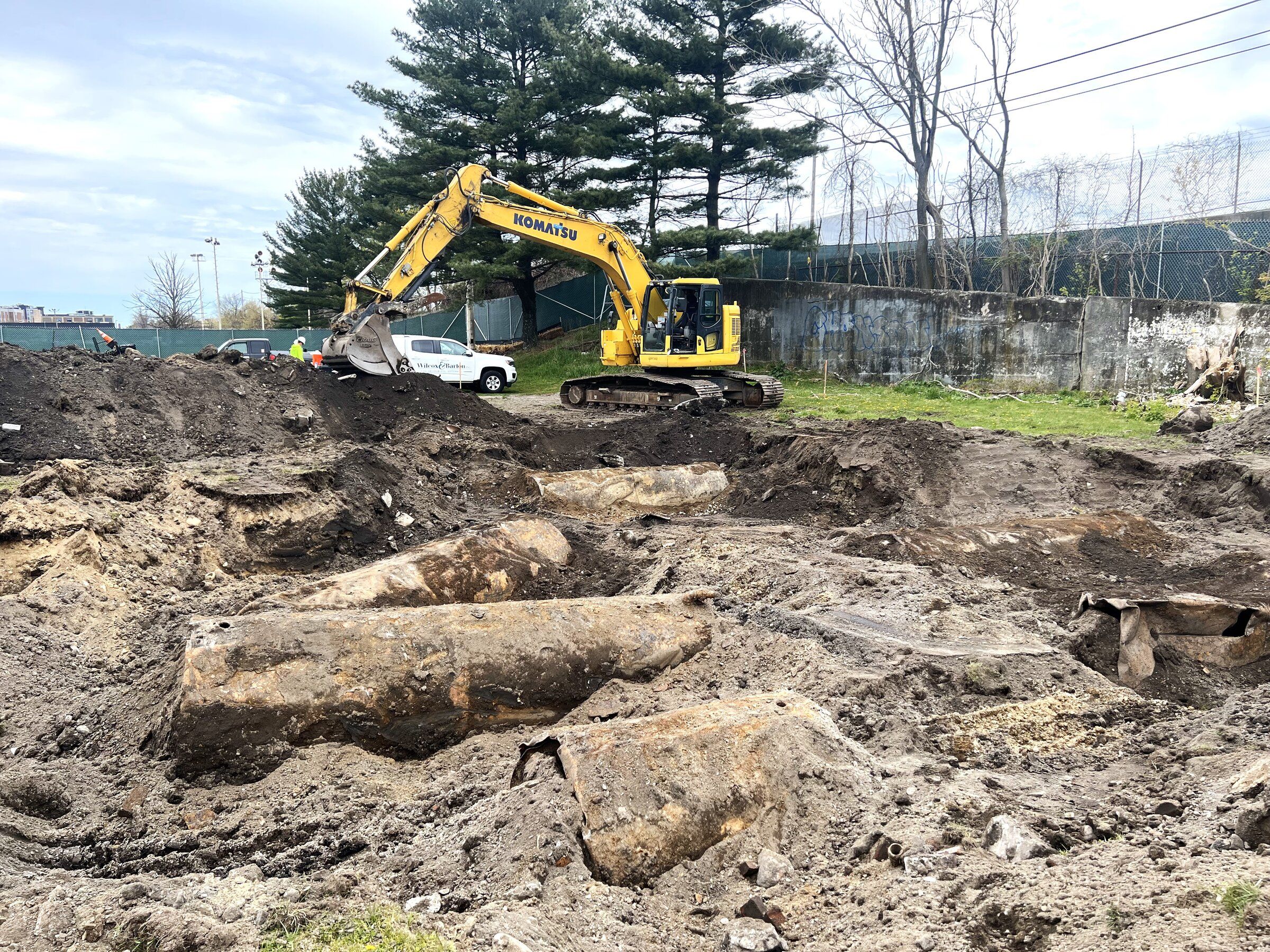 Excavator beside steel storage tanks unearthed during the excavation